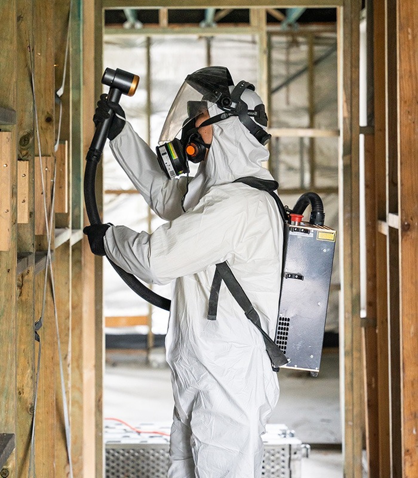 Licensed asbestos removal operator in protective equipment on site