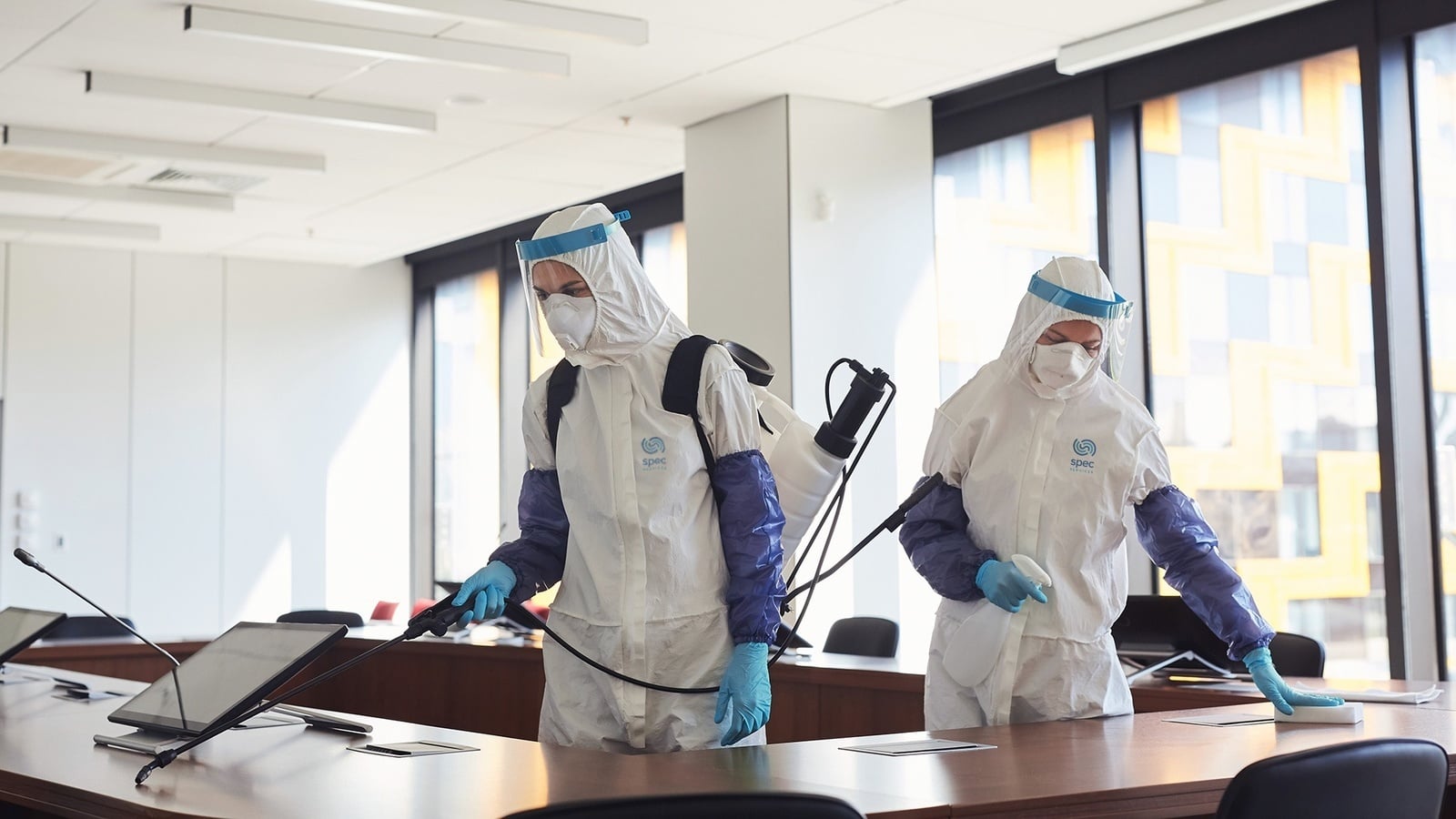 Forensic cleaning professionals working in full protective equipment
