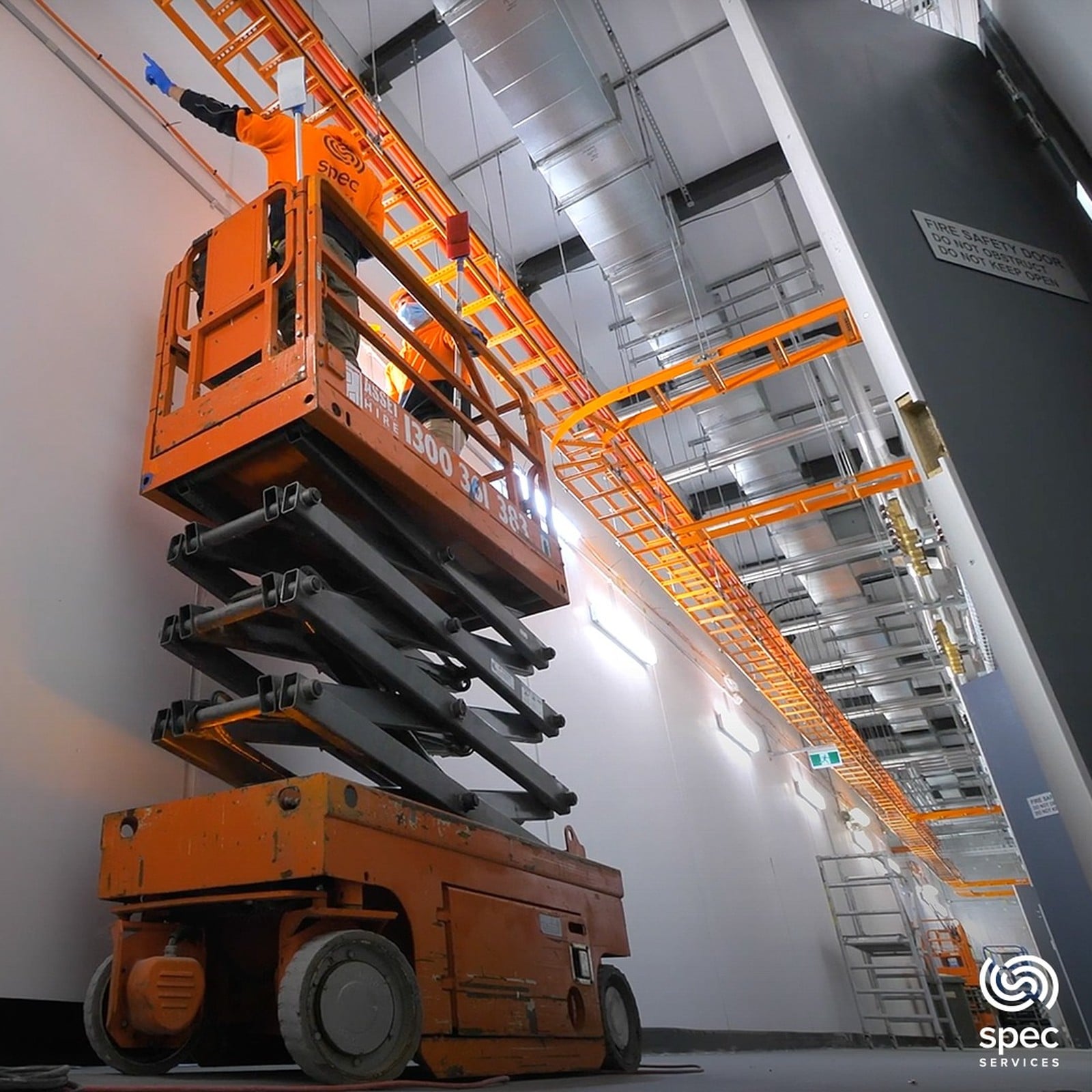 Worker in a scissor lift carrying out industrial cleaning work