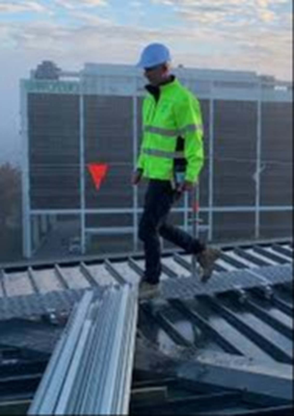 Worker on a roof in safety gear during industrial cleaning work in Canberra